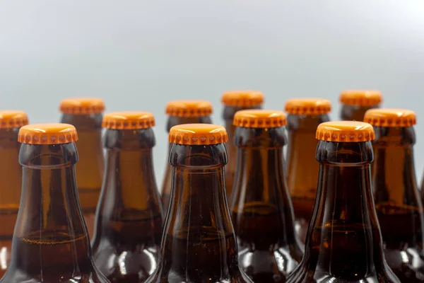 白を基調としたラベルのない自家製ビール オレンジキャップ付きのビールボトルのクローズアップ写真 オレンジキャップ付きの分離ビールボトル — ストック写真