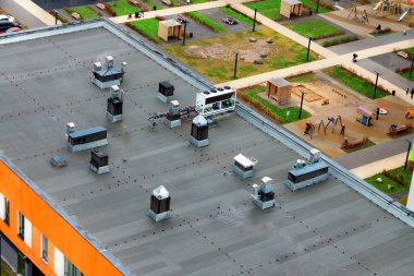 Modern bir apartmanın tepesinde kliması olan düz bir çatı. Kentsel gelişim ve sürdürülebilir yaşam tarzı kavramı.