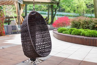 Bir modern hasır sandalye dinlenmek için rahat bir yer iyi korunmuş lobi yeşil bahçesi yaz güneşli bir gün.