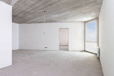 Ev tadilatı. İnşaat iç inşaat alanı beton duvarlar, mavi claudy gökyüzü penceresi açık beyaz oda onarım altında.