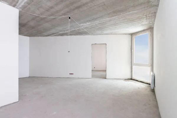 Renovation home. Building construction interior site with concrete walls, blue claudy sky window view light white clean room under repairing work.