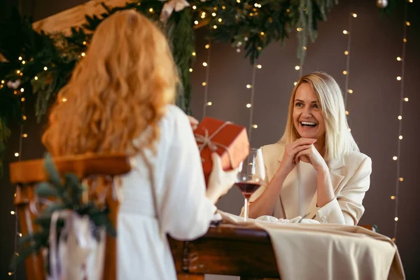 Lezbiyen çift restoranda yemek yiyor. Kız sevgilisine hediye veriyor.