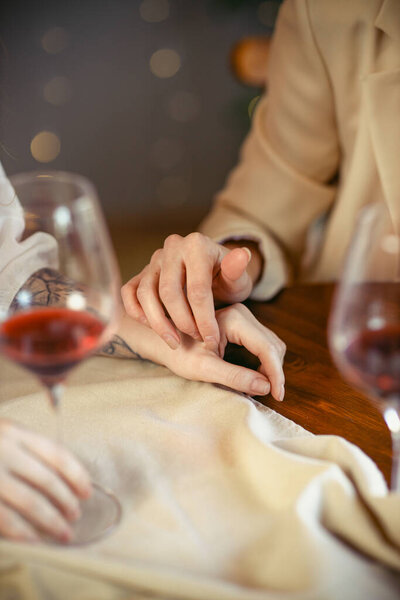 lesbian couple having dinner in a restaurant Close-up of hands of a loving couple