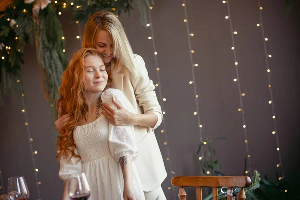 Lesbian Couple Having Dinner Restaurant One Girl Hugs Her Beloved lizenzfreie Stockbilder