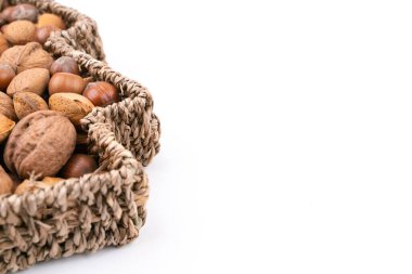 Beyaz arka planda izole edilmiş bir sepet dolusu karışık fındık dolu yüksek açılı stüdyo çekimi. Sağ tarafta boş yer var. Noel konsepti.
