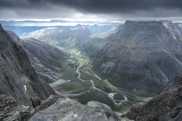 Θέα από την κορυφή του Trollveggen, ή Troll Wall, στη Νορβηγία. Διάσημη άποψη στα Νορβηγικά βουνά. Δραματική οροσειρά σε μια κρύα και συννεφιασμένη μέρα του φθινοπώρου. Winding ποταμού στην κοιλάδα κάτω. — Φωτογραφία Αρχείου