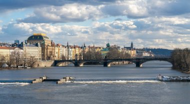 Prag, Çek Cumhuriyeti - 02.19.2022: Vltava nehri ve arkasında Ulusal Tiyatro bulunan şehir güzel bir kış gününde Charles Köprüsü 'nden izlendi. Prag 'ın tarihi merkezi. Ünlü Avrupa başkenti.