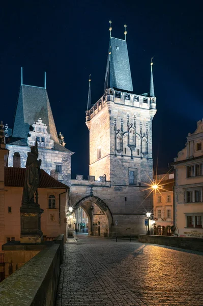 Praga, Chequia - 02.17.2022: Vista de Mala Strana Bridge Towers desde Charles Bridge en la noche oscura. Centro de Praga sin gente. Hermosos edificios históricos en la capital de Europa central. — Foto de Stock