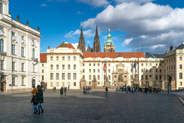 Praga, Chequia - 02.19.2022: La gente caminando frente a la puerta principal del Castillo de Praga en un hermoso día soleado. — Foto de Stock