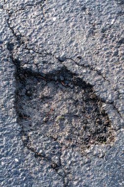 Asfalt yolundaki esrar deliği. Delikli hasarlı otoyol. Kıştan sonra onarılması gereken tehlikeli delikler. .