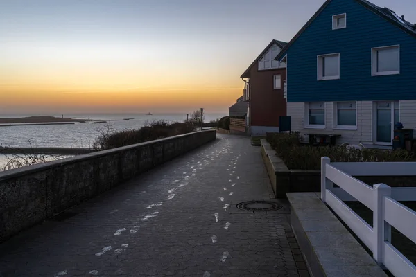 Helgoland, Alemania - 02.27.2022: Huellas congeladas en un camino de hormigón junto al mar en la isla alemana de Helgoland en el mar del Norte. Momentos antes del amanecer. — Foto de Stock