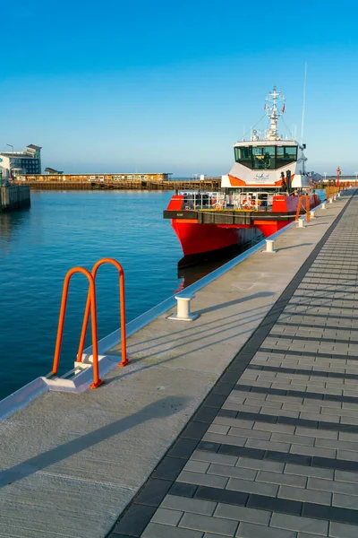 Helgoland, Alemania - 02.27.2022: Catamarán rojo atracado en la bahía en el puerto de Helgoland. Soleado día de invierno en el archipiélago alemán en el mar del Norte. — Foto de Stock