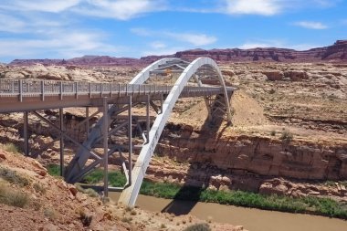Utah, ABD 'deki Colorado Nehri' nin karşısındaki çelik köprüden geçmek. Amerikan çölünde klasik bir köprü kemeri. Amerika 'nın batısına git. Çok sıcak, güneşli bir bahar günü. Amerika 'yı boydan boya geç.