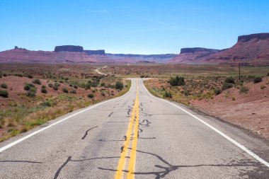 ABD yolu, baharın güzel bir gününde Utah çölünde kızıl kayalıklar arasında dolanıyor. Amerika 'nın güneybatısından manzaralı bir yolculuk. Uzak bir yolda gitmek
