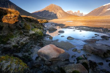 Baykuş nehri yatağı Mt. Asgard, Akshayuk Geçidi, Nunavut. Güneşli sabahın erken saatlerinde güzel kutup manzarası. Uzak ufuktaki ikonik dağlar. Vahşi kuzey.