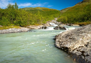 Vahşi buzul nehri yeşil ve uzak kutup bölgesinden geçiyor. İsveç, Sarek Ulusal Parkı 'ndaki Balgatjahka Nehri. İsveç Laponya 'sında güneşli güzel bir gün. Laponya 'da yürüyüş. Kuzey Kutbu manzarası