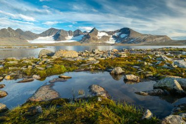 Günün son ışığında Laponya 'nın uzak kutup çöllerinde buzulları olan kayalık dağlar. Sarek Ulusal Parkı, İsveç. Barddetjahkka, Balgattjahkka, Lullihatjahkka tepeleri, Balgatjiegna buzulu.