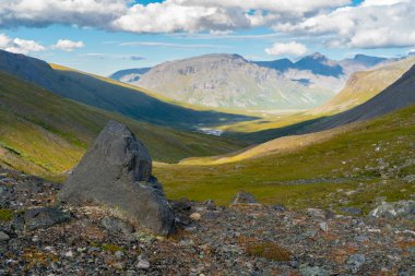 Güneşli bir yaz gününde, uzak Kuzey Kutbu 'ndaki engin dağ vadisi. Arkasında Laddebakte Dağı olan Noajdevagge Vadisi, Sarek Ulusal Parkı, Lapland, İsveç.