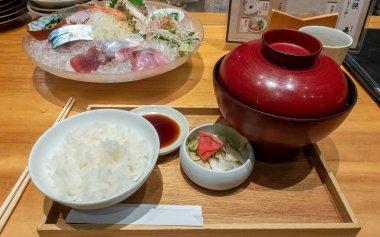 Tokyo, Japonya - 09.14.2022: Japon restoranında öğle yemeği menüsü. Sashimi kasesi ve tepside pilav ve çorba kasesi.