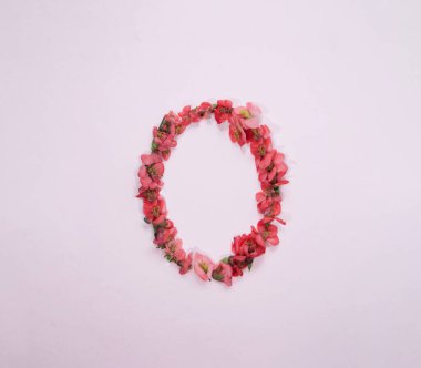 Pembe pastel arka planda bahar çiçeklerinden yapılmış Paskalya yumurtası. Paskalya özel bileşimi.