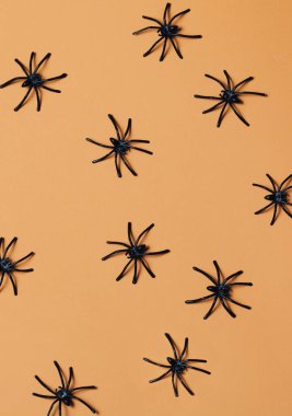 Turuncu arka planda örümceklerin oluşturduğu desen. Yaratıcı Cadılar Bayramı, yakın plan, konsept.