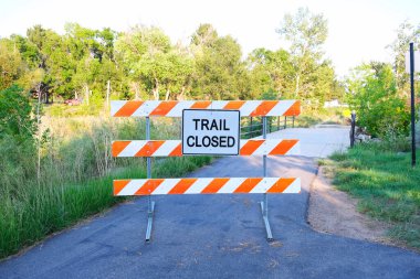 Şehir yürüyüş alanında yürüyüş yolu boyunca beyaz ve turuncu çizgili kapalı uyarı işareti.. 