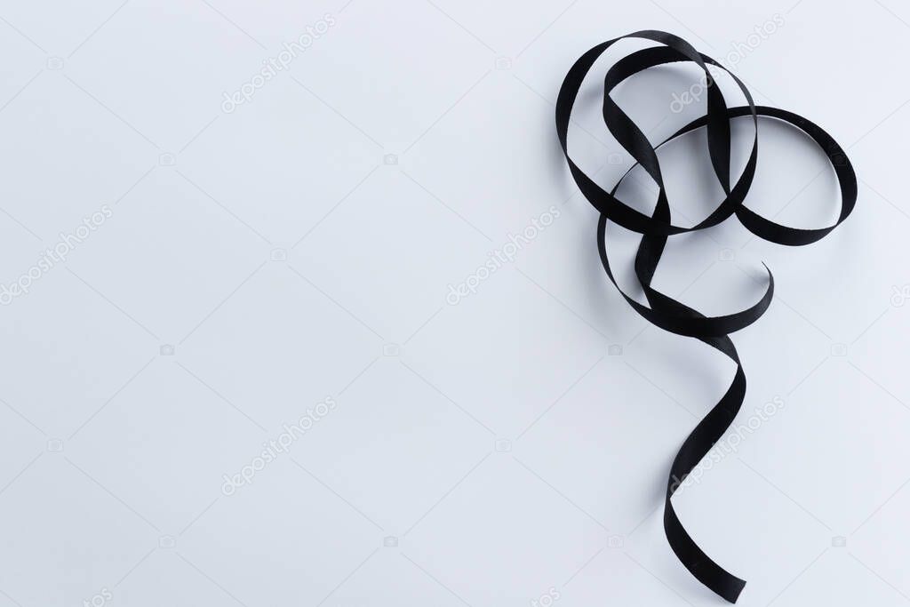 Black ribbon on a white background with a copy space.