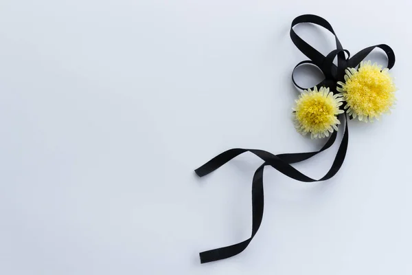 Fita funerária preta com duas flores amarelas. — Fotografia de Stock