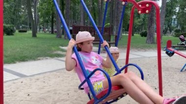 4k Twins kızları parkta salıncakta sallanıyor..