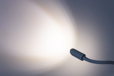 Lambanın ışığı duvarda. Lamba yanıyor. Metin için yer.