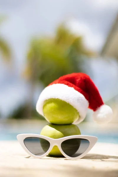 Bonhomme de neige fait de pommes dans un chapeau de Noël debout près de la piscine. Gros plan. Mise au point sélective, fond flou. — Photo