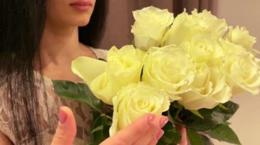 Gülleri seven bir kız. Güllerle gülümseyen kız.