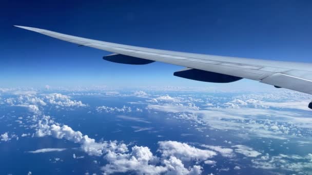 Kilátás a repülőgép megvilágítójából az óceánra és a felhőkre. — Stock videók