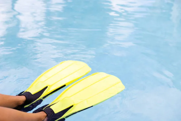 Patas femeninas en aletas sobre fondo de agua azul. Concepto de vacaciones de verano. —  Fotos de Stock