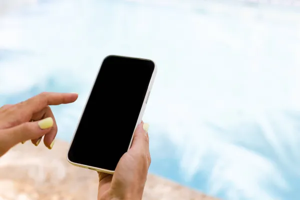 Akıllı telefonu tutan ve işaret parmağıyla yazan bir kadın. Yaklaş, taklit et..