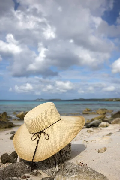 雌性草帽躺在沙滩上,上面有珊瑚.海景。暑假的概念. — 图库照片