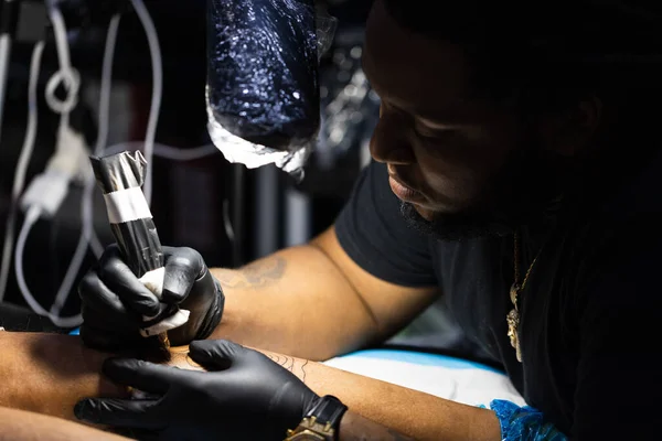 Mestre de tatuagem está ocupado com o trabalho no estúdio de tatuagem. Fechar. — Fotografia de Stock