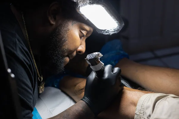 Retrato de tatuador ocupado com seu trabalho no estúdio de tatuagem. Fechar. — Fotografia de Stock