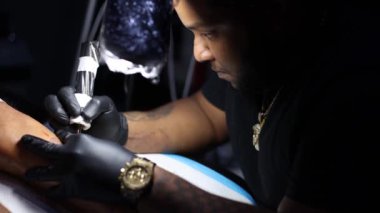 Dövme ustasının portresi dövme stüdyosunda çalışmakla meşgul. Kapat..