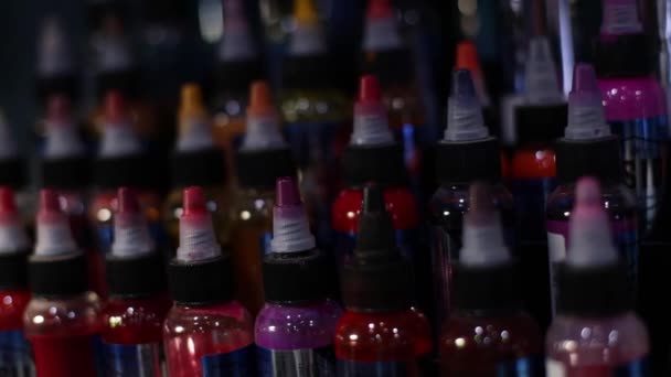 Palette of multicolour tattoo inks. Tattoo salon. Selective focus, blurred. — Stock Video
