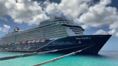 Yolcu gemisi. Turkuaz renkli denizi olan bir limanda kalan yolcu gemisi..