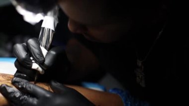 Dövme ustası elleri dövme yapmakla meşgul..