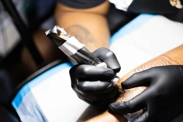 Male hands in black gloves with tattoo machine. Close up. — Stockfoto