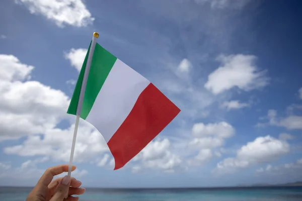 Женщина держит итальянский флаг на морском фоне. — стоковое фото