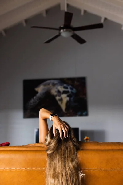 Kanepede oturan kız eliyle başını tutuyor..