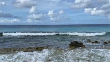 Tropical sandy shore of a beach with dead corals washed by azure sea. Seascape.