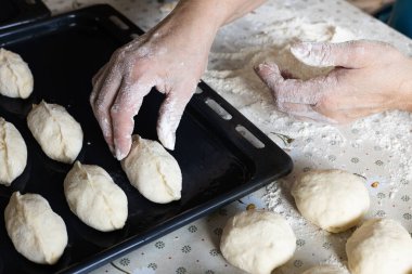 Ev yapımı. Kadın turta yapıyor ve onları yemek tepsisine koyuyor.. 