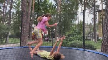 4k Parkta trambolinde zıplayan iki küçük kız. 