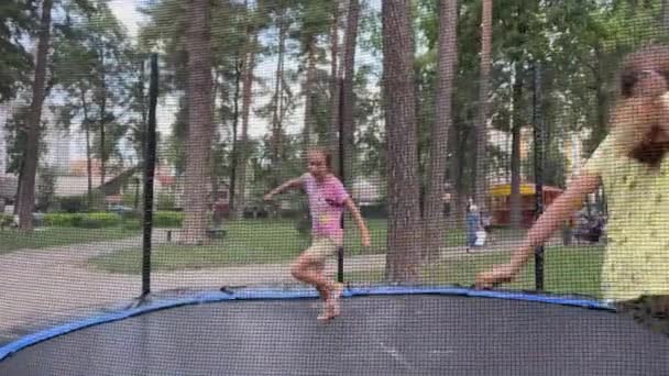 4k Δίδυμα κορίτσια παίζουν catch-up σε ένα τραμπολίνο. — Αρχείο Βίντεο