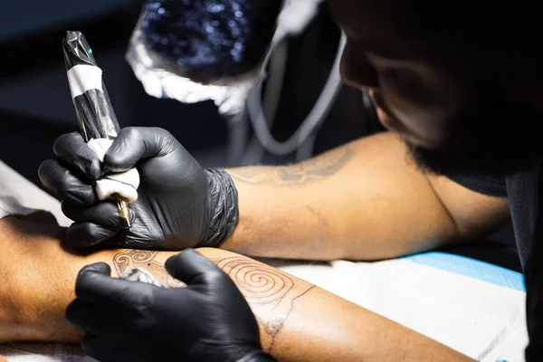 Mestre de tatuagem está ocupado com seu trabalho no estúdio de tatuagem. Fechar. — Fotografia de Stock